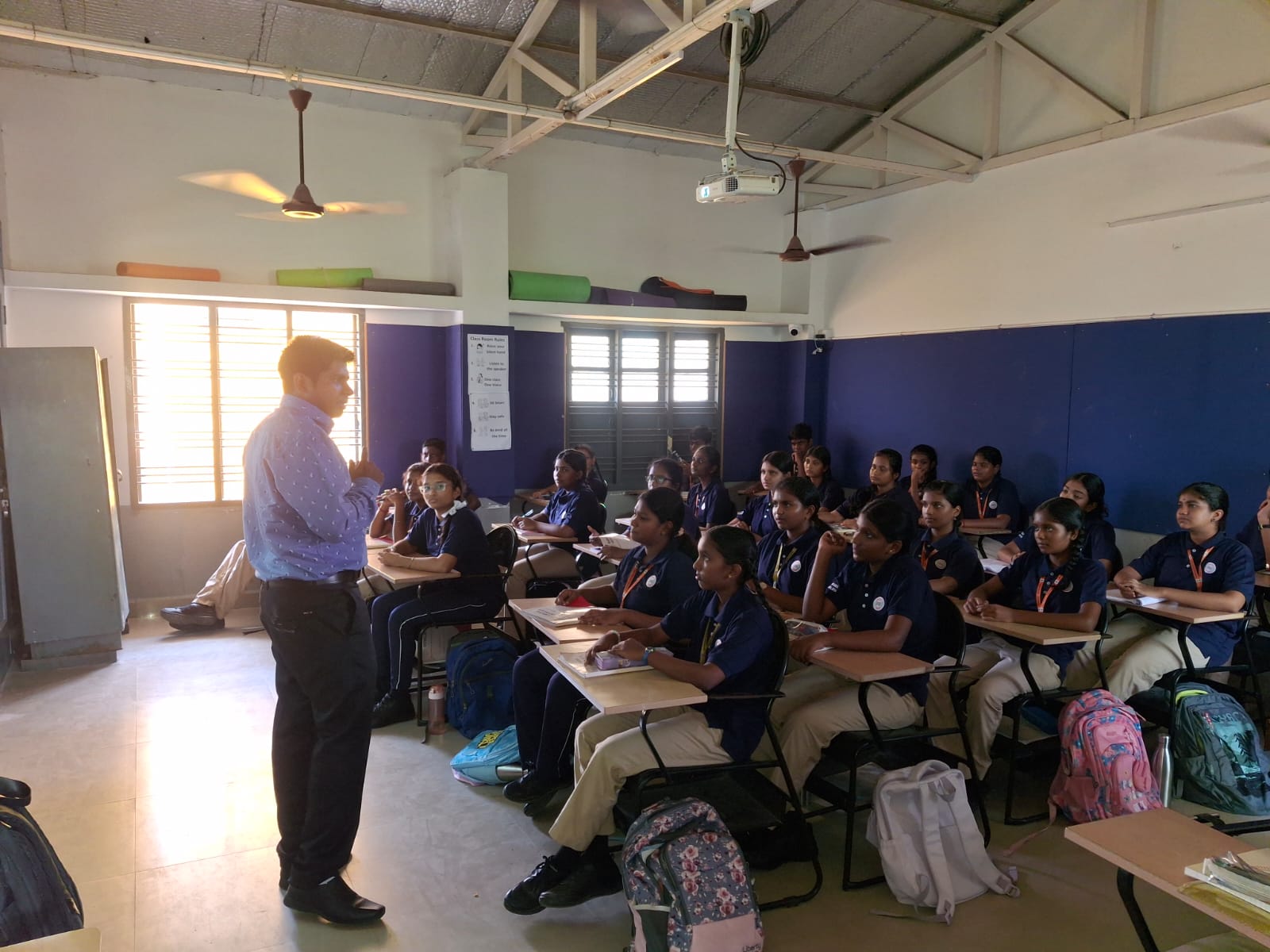 An educator teaching a classroom of students seated at desks